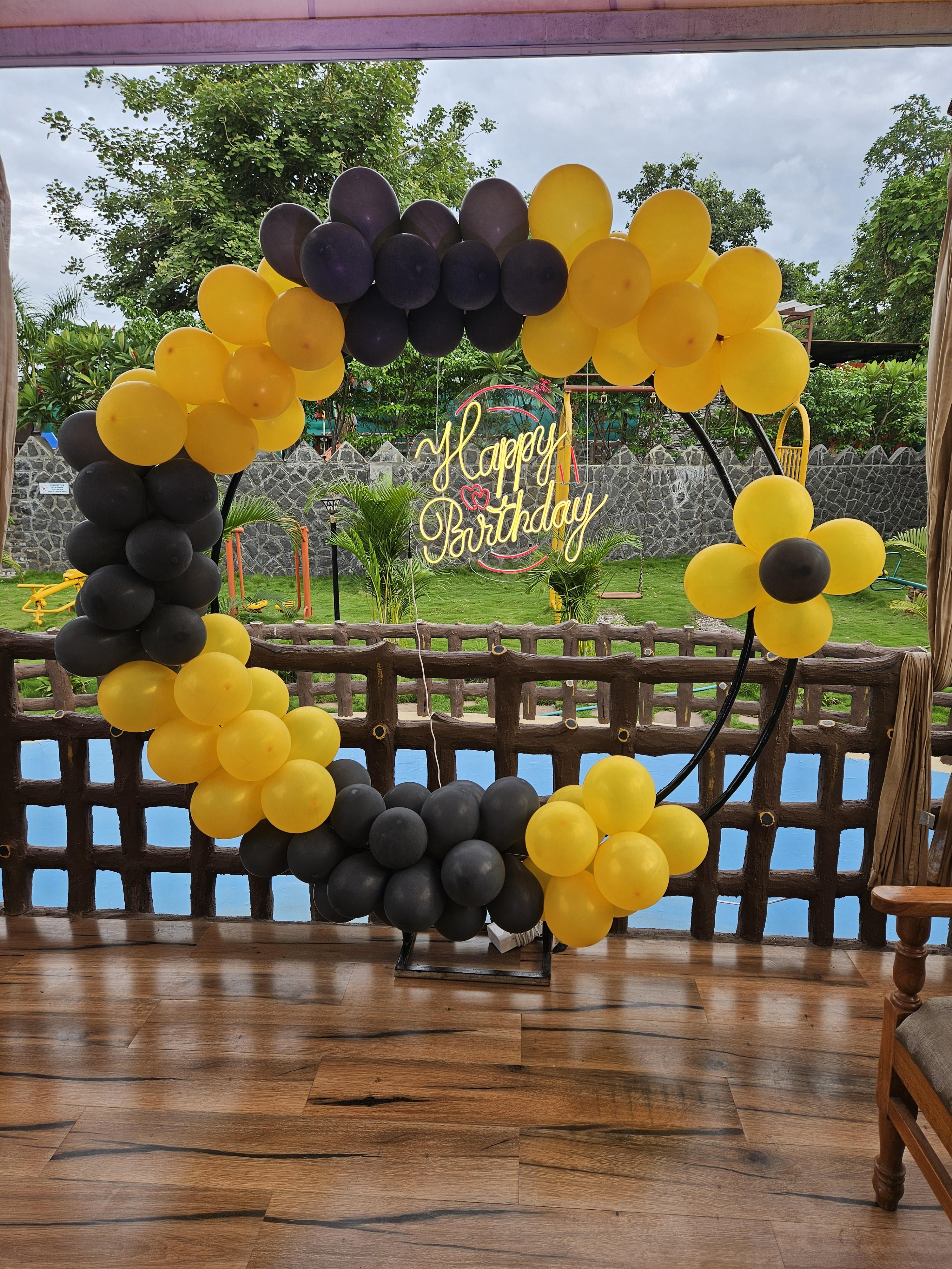 A picture-perfect birthday celebration at Nature Nest! This elegant black-and-yellow balloon arch creates a vibrant yet classy vibe, beautifully complementing the lush greenery and serene poolside view. The glowing 'Happy Birthday' sign adds a magical touch, making this setup ideal for a memorable celebration