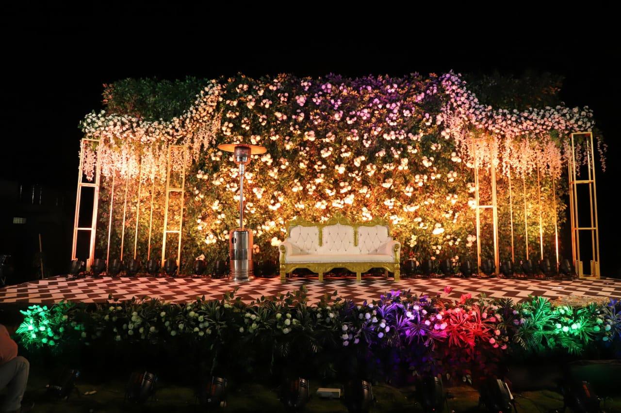 A serene and elegant outdoor setup, perfect for intimate gatherings and celebrations. The lush greenery, subtle floral arrangements, and neatly arranged seating create a welcoming and refreshing ambiance for guests to enjoy.