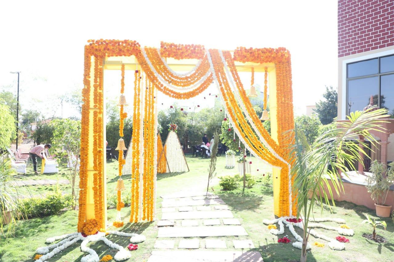 This beautiful marigold-adorned entrance sets the perfect tone for a traditional celebration. The vibrant floral decor, hanging bells, and intricate details create a warm and festive ambiance, making it an ideal setting for a wedding or special occasion.